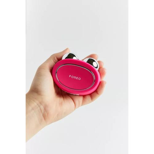 Professional using microcurrent face toning device in salon setting